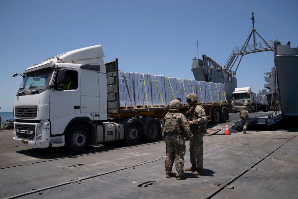 Off Gaza’s coast, truckloads of aid roll off a US military pier – only to remain uncollected